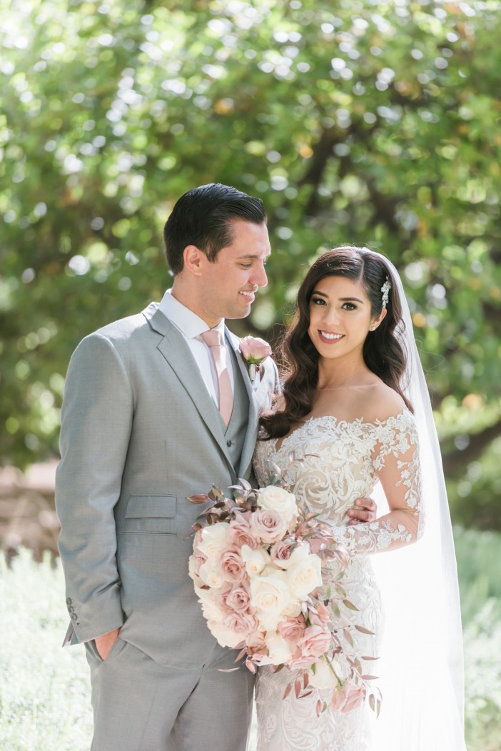 Happy bride and groom just married embracing on the beautiful outdoor property of Las Vegas JW Marriott Resort & Spa.