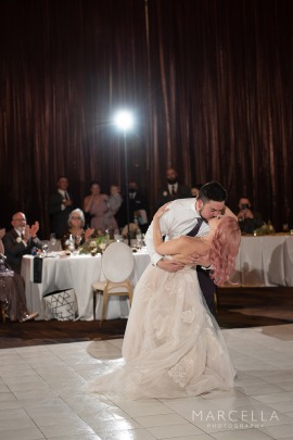 A fun first kiss dip showing off bride's pink hair.