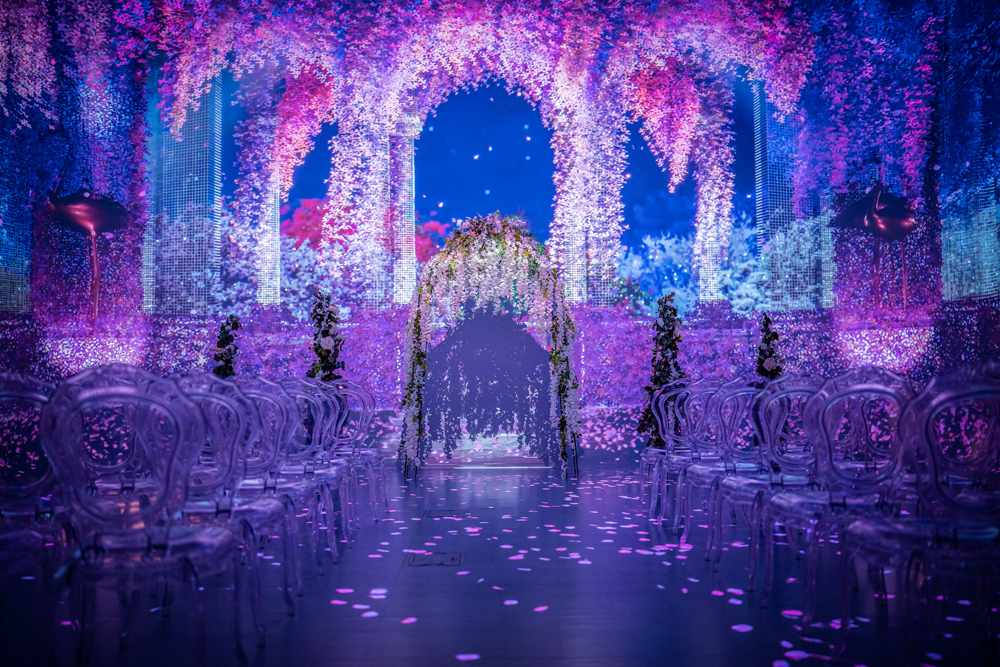 romantic wedding venue space in purple and blue. flower arches projected on the walls at Illuminarium Las Vegas