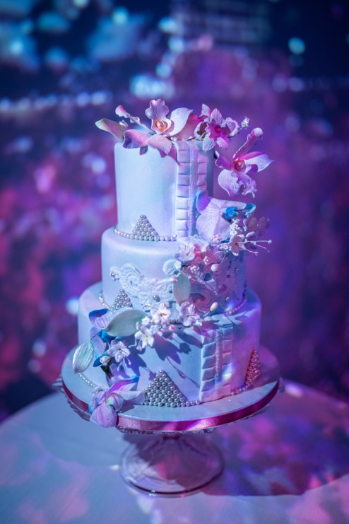 small blue wedding cake with edible flowers from Nutriente bakery studio