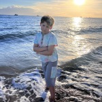 Charlie in Lahaina, Hawaii in front of a beautiful sunset over the ocean. Hawaii Destination Wedding