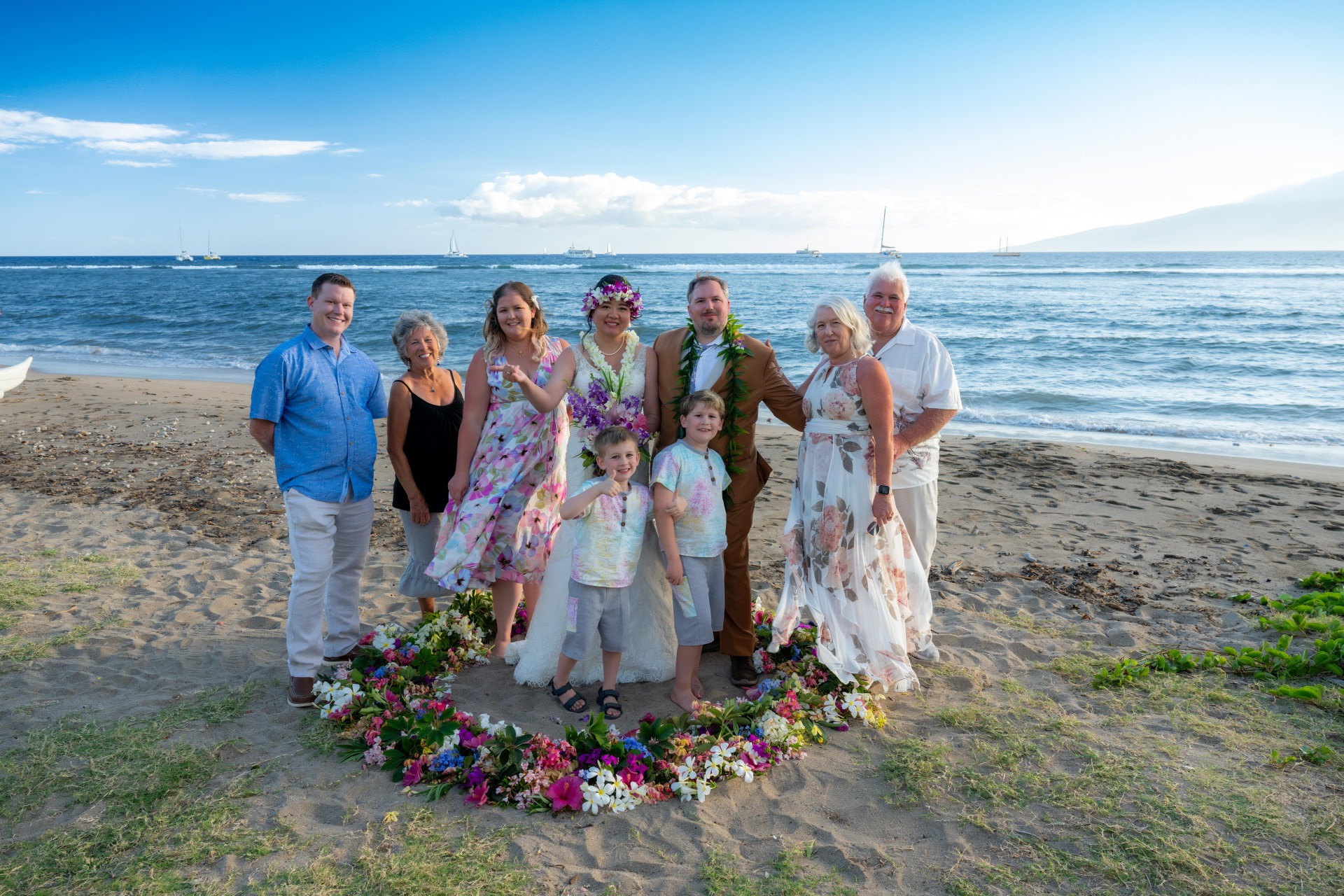 Ty and Ying's destination wedding in Lahaina, Hawaii. Happy family surround the Bride and Groom on the beach where the wedding was held