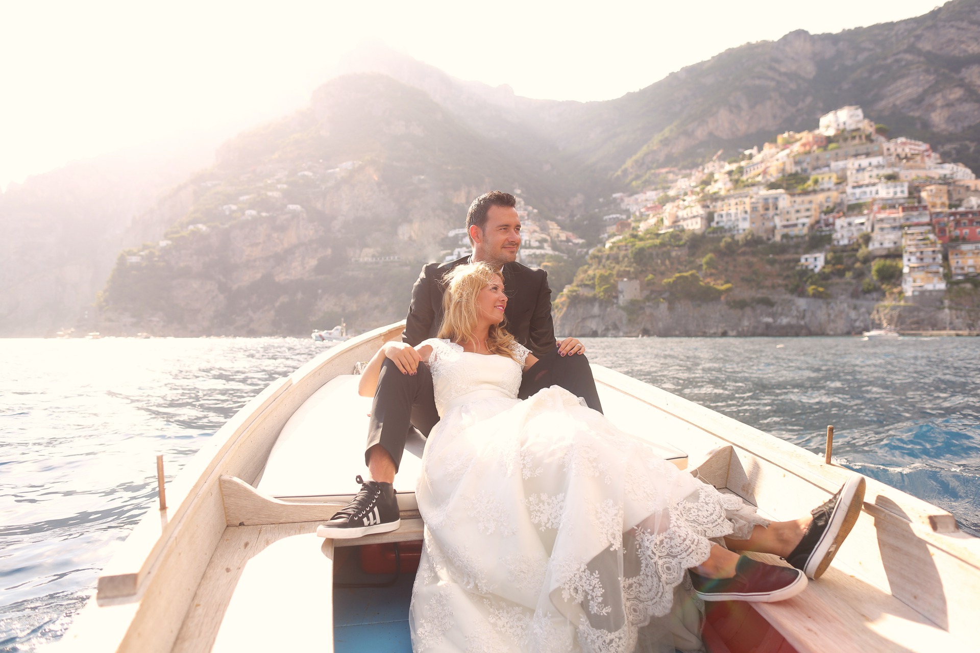 Gorgeous Bride And Groom lounge in boat off the coast of a dream destination