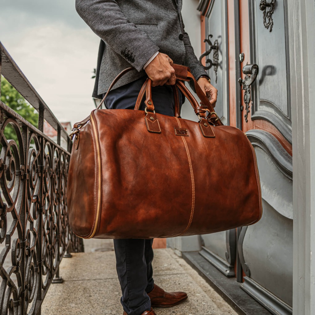 Grand Nahast Reisikott Ulikonnale - Man holding fine leather suit bag full of his wedding packing essentials