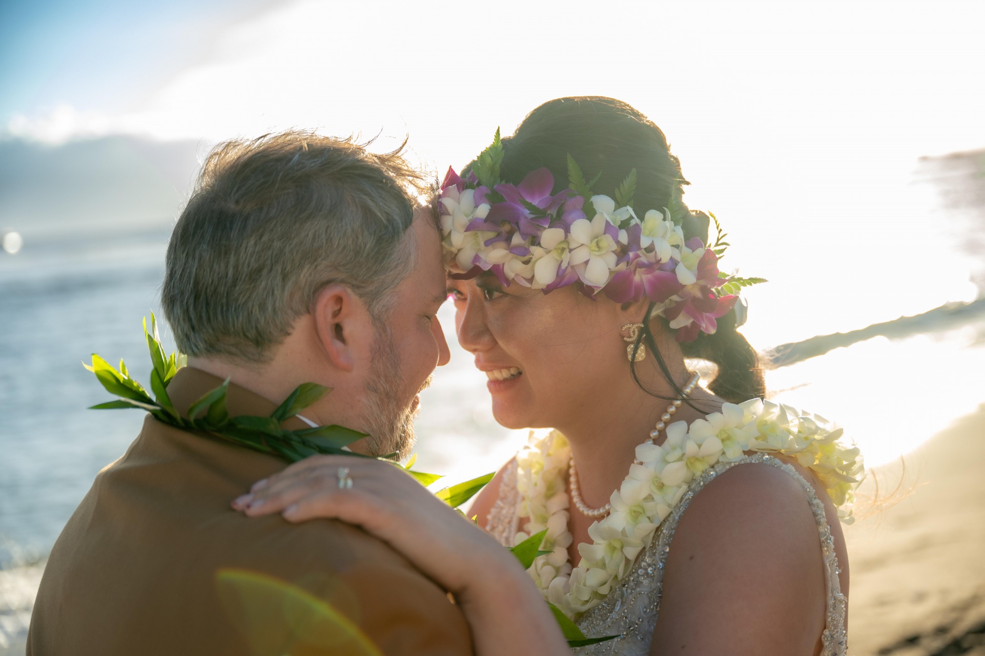 Ty and Ying share a special moment in front of the beach sunrise at their Maui destination wedding