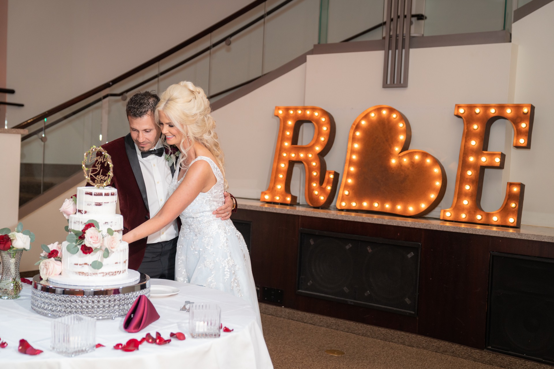 Happy couple cut their wedding cake at their Burgundy and Blush wedding in Las Vegas.